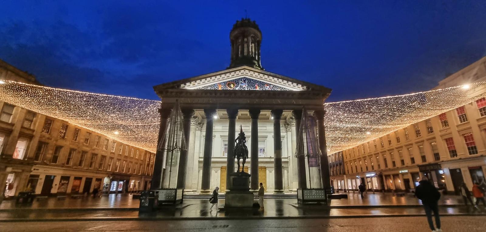 The Gallery of Modern Art and Duke of Wellington statue beneath festive lights in George Square, Glasgow