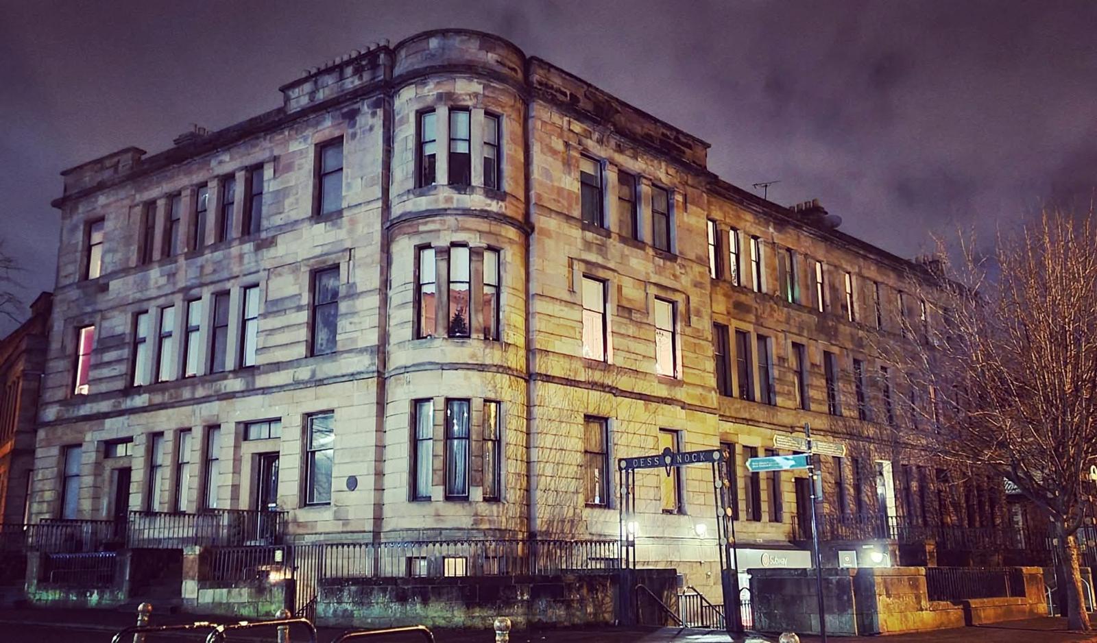A grand Glasgow sandstone building lit in the evening